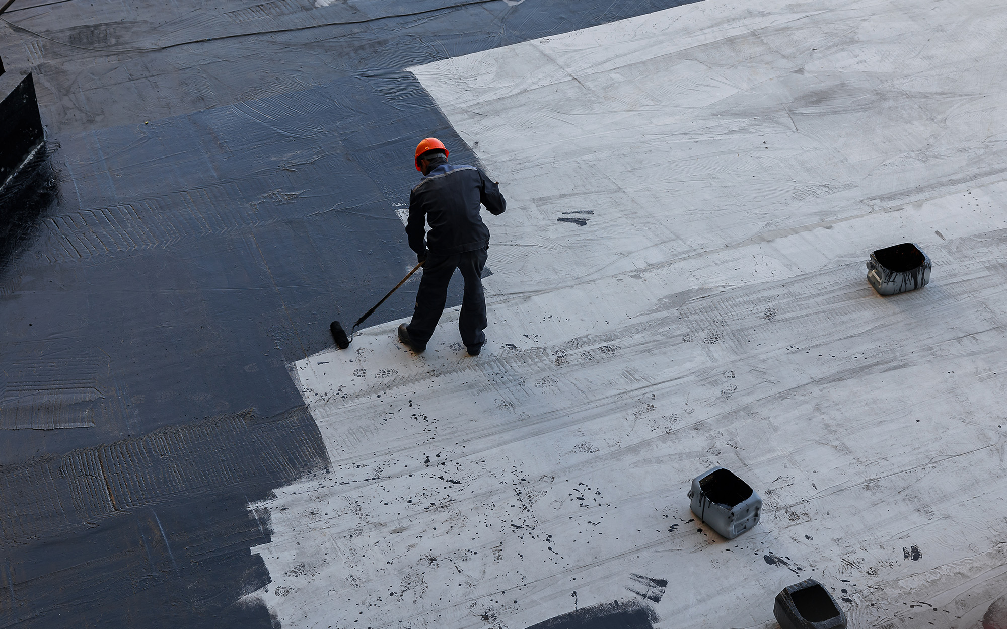 A Worker Applies Bitumen Mastic To The Foundation
